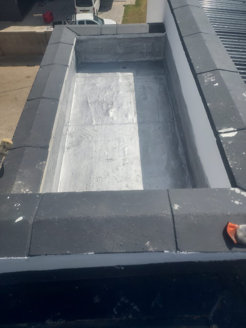 Coated rooftop channel beside a metal roof